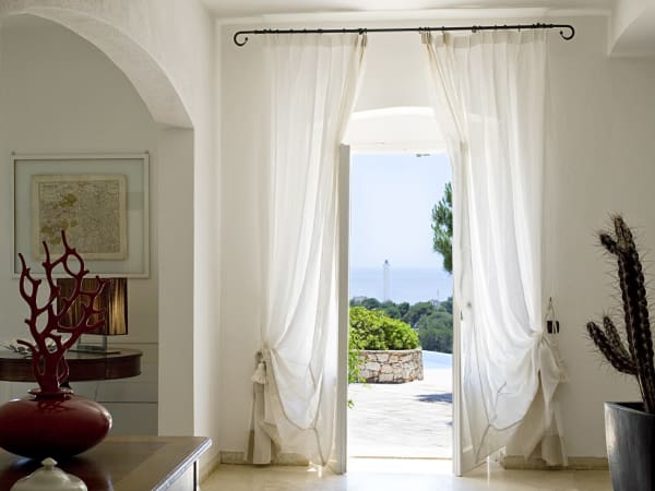 French windows lead out onto the shaded terraces overlooking the pool and the sea.